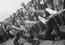 A crowd of people watching a tug of war match during the opening of a new sports ground at Elstree, 1949.