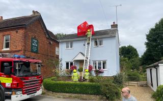 Royston firefighters retrieve the umbrella from the pub roof